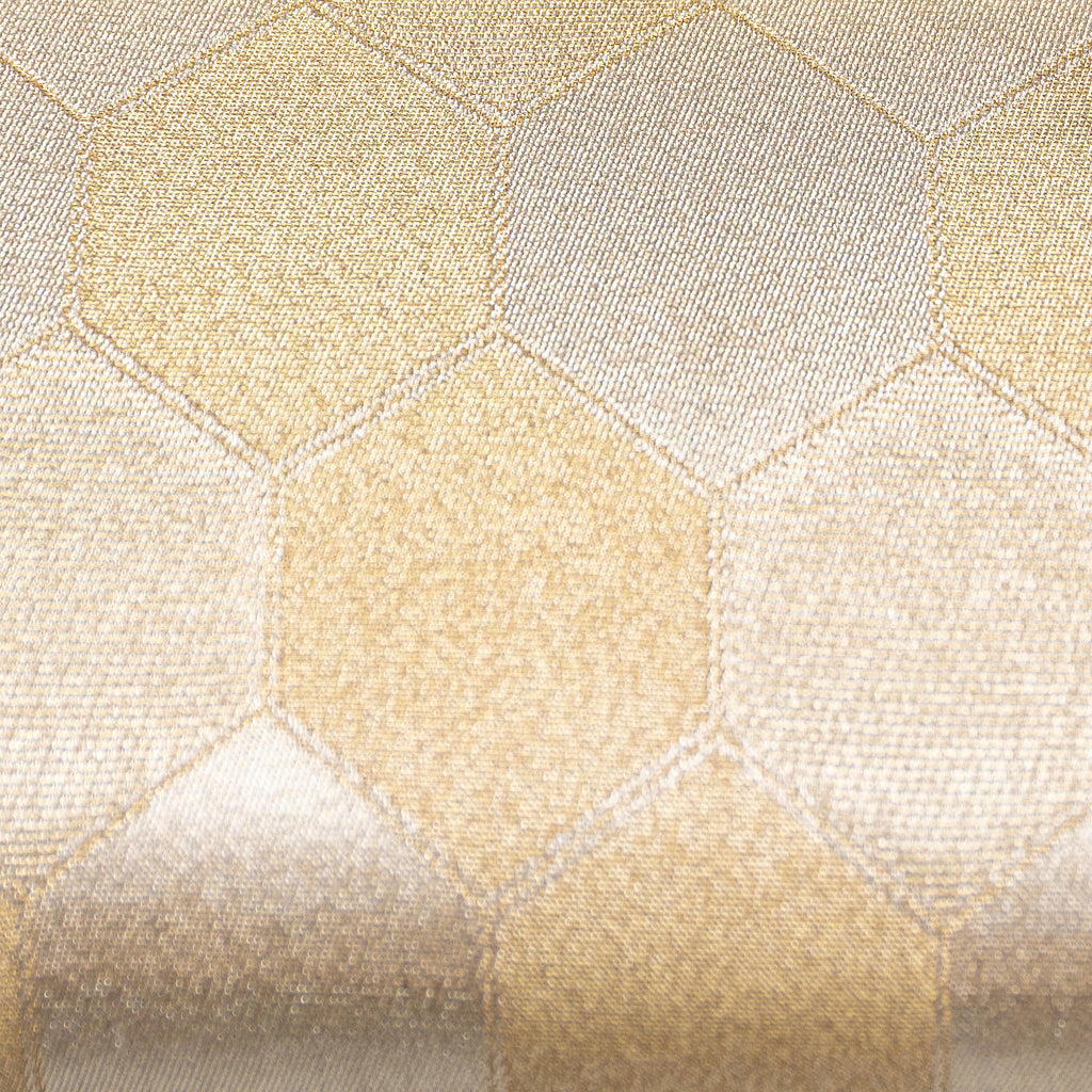 Detail of the vintage Japanese silk clutch's textured gold surface with intricate fortune hexagon patterns, viewed from a