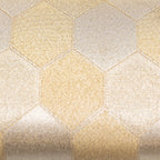 Detail of the vintage Japanese silk clutch's textured gold surface with intricate fortune hexagon patterns, viewed from a