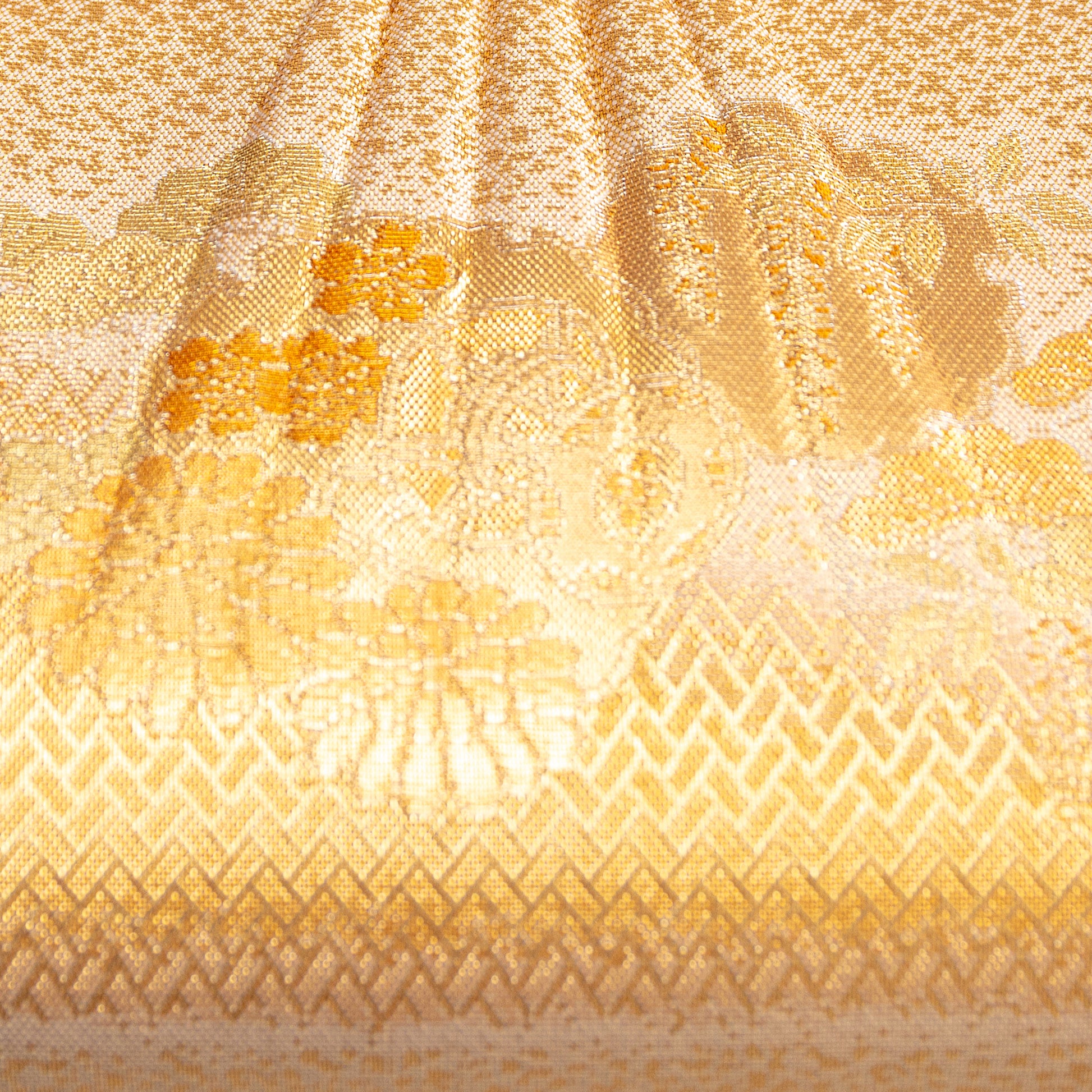 Close-up of a textured gold fabric with patterns, front of a vintage Japanese gold clutch bag with floral and drum patterns.