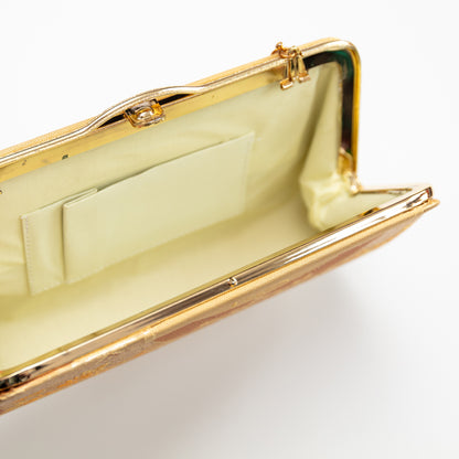 Gold clutch bag with a white interior on a light gray background