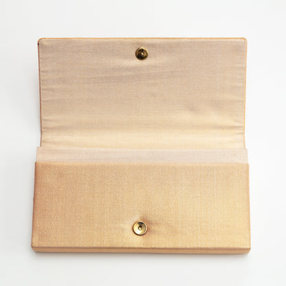 Metallic gold woven silk envelope clutch with gold stud closure on a white background