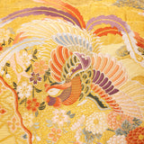 Detail of the front of the cushion, a flying golden phoenix or pheasant woven in gold, purple and orange silk threads.