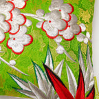 Close-up of textured silver crane embroidery detailing on the vibrant kimono silk bolster cushion edge.