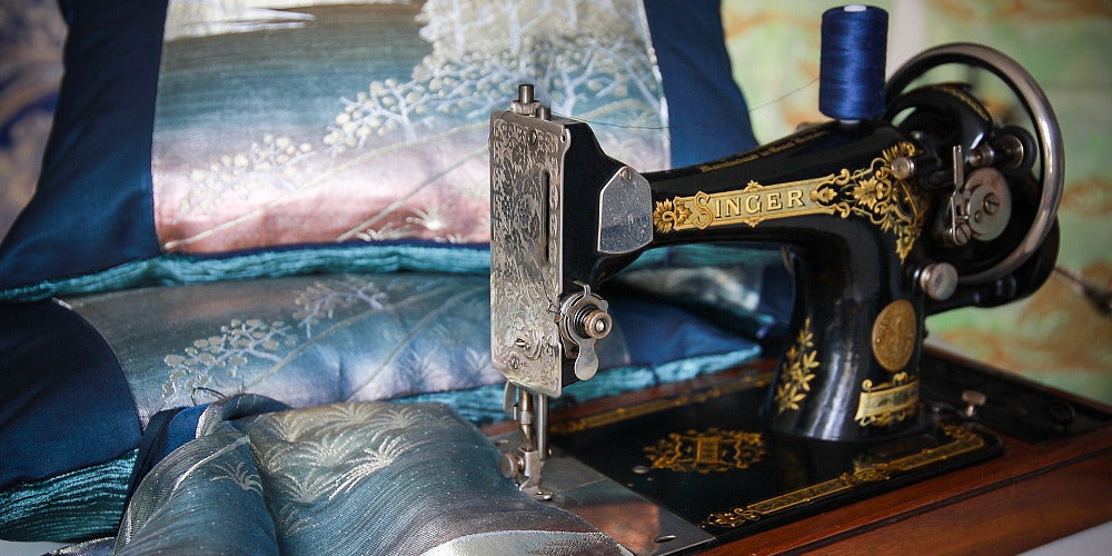 Vintage Singer sewing machine with blue obi silk cushions in the background