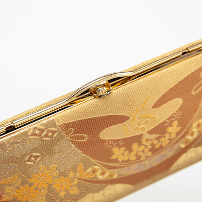 Gold clutch with floral abstract design on a white background