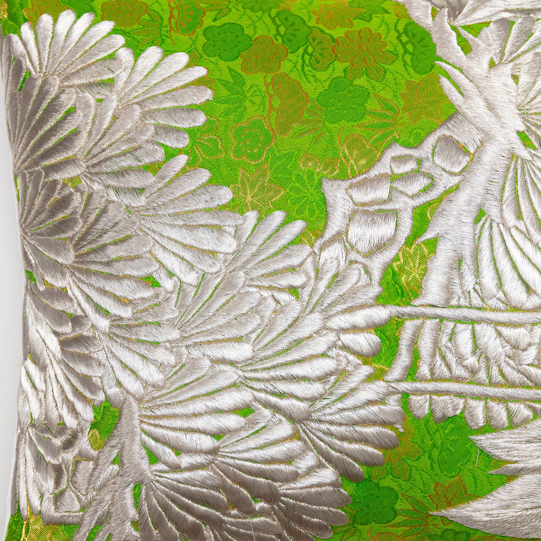 Close-up of intricate silver crane embroidery highlighting textured kimono silk fabric and detailed stitching on the