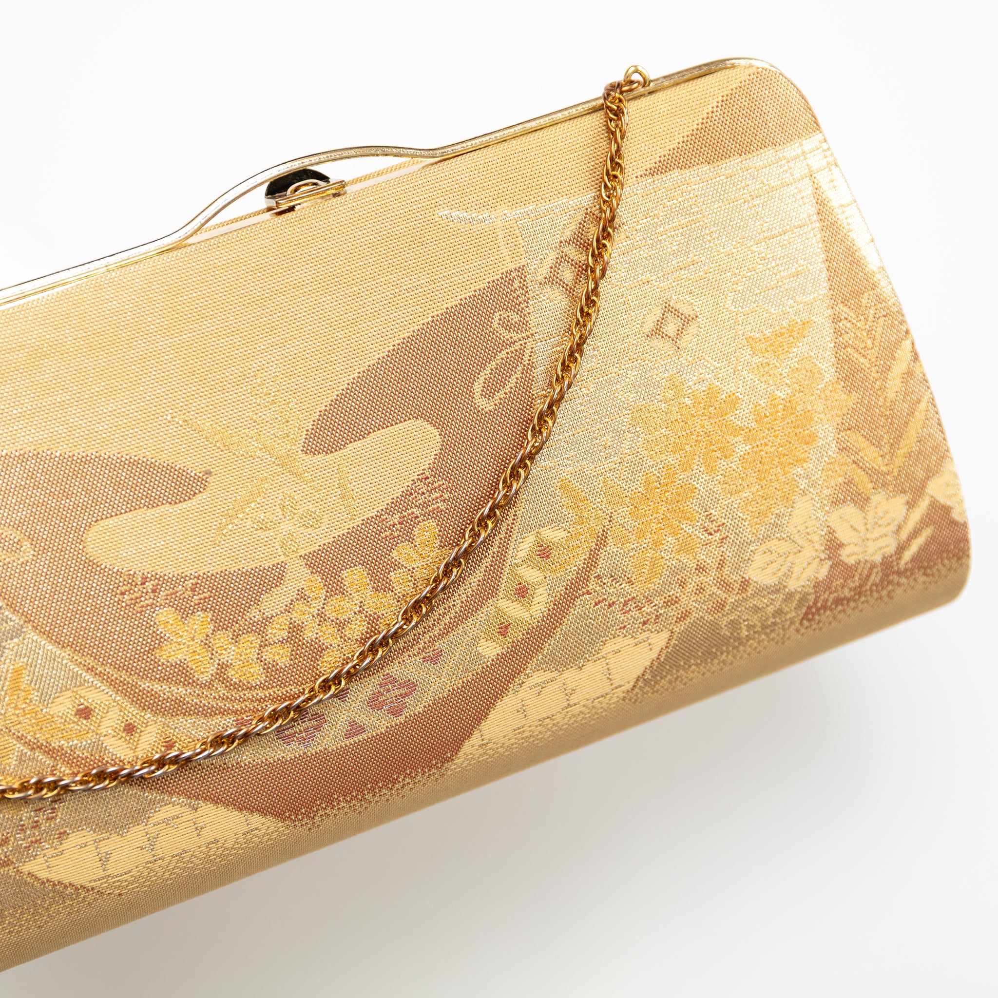 Close-up of intricate gold floral embroidery on the vintage Japanese silk clutch’s front panel, highlighting detailed