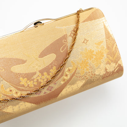 Gold vintage Japanese metallic clutch bag with floral patterns on a white background
