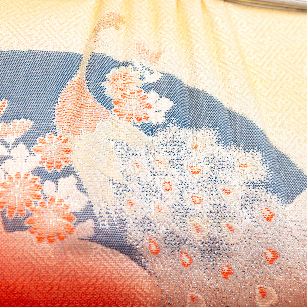 Close-up of intricate peach peacock embroidery highlighting fine silk threads and metallic accents on the vintage kimono