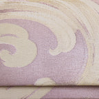 Close-up of the lilac silk clutch's intricate woven pattern and subtle wave motif along the top edge, showcasing