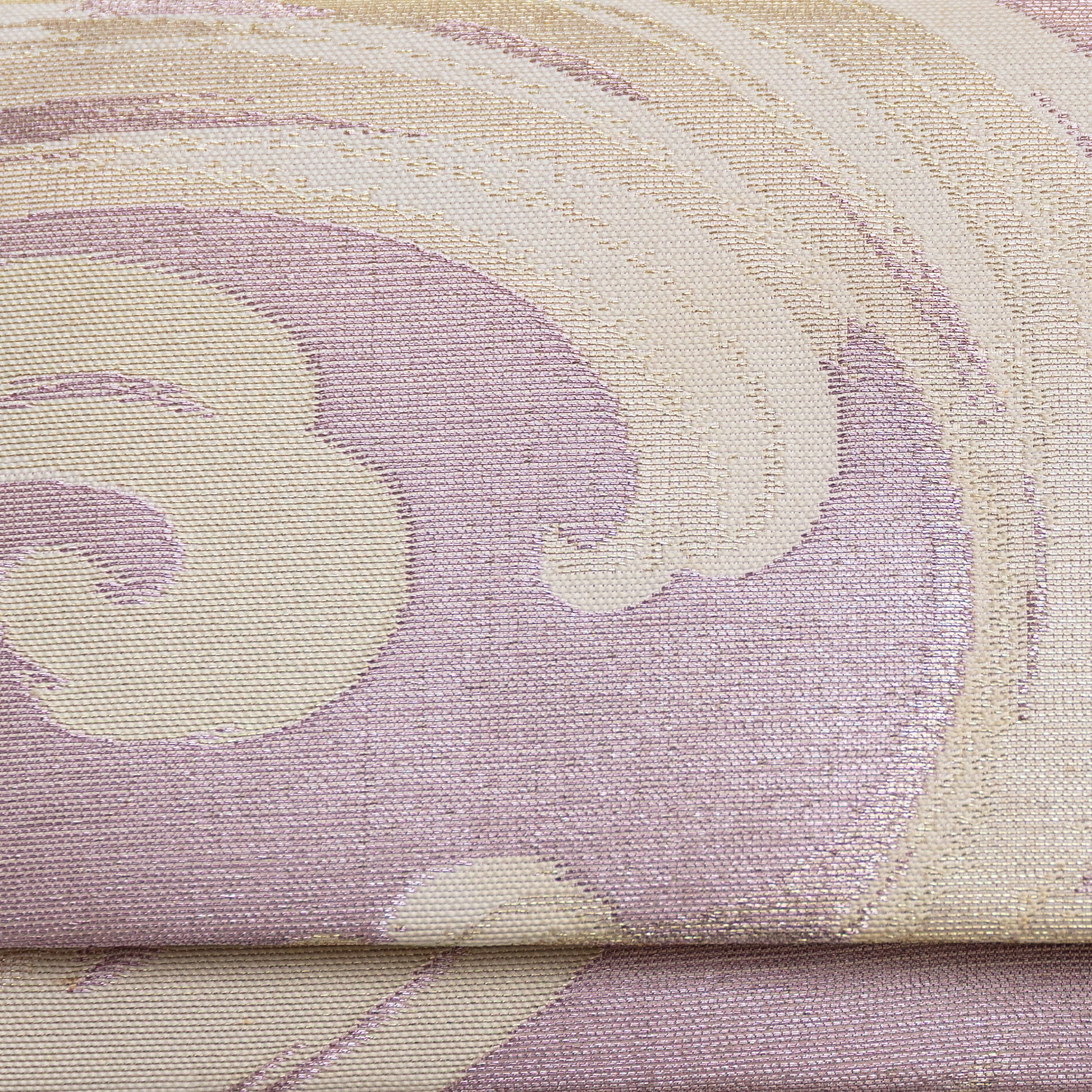Close up detail of the front of the pink lilac clutch bag. Woven metallic brocade with cream and silver threads in a wild wave pattern.