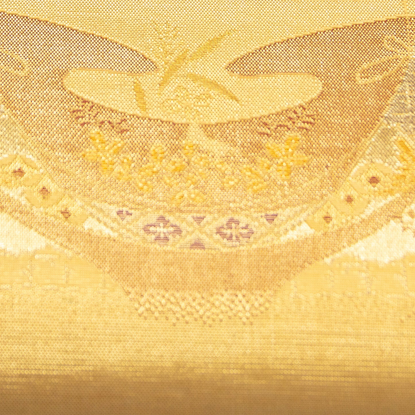Close-up of gold fabric with intricate patterns and designs. Gold kimono silk clutch bag detail of pattern.