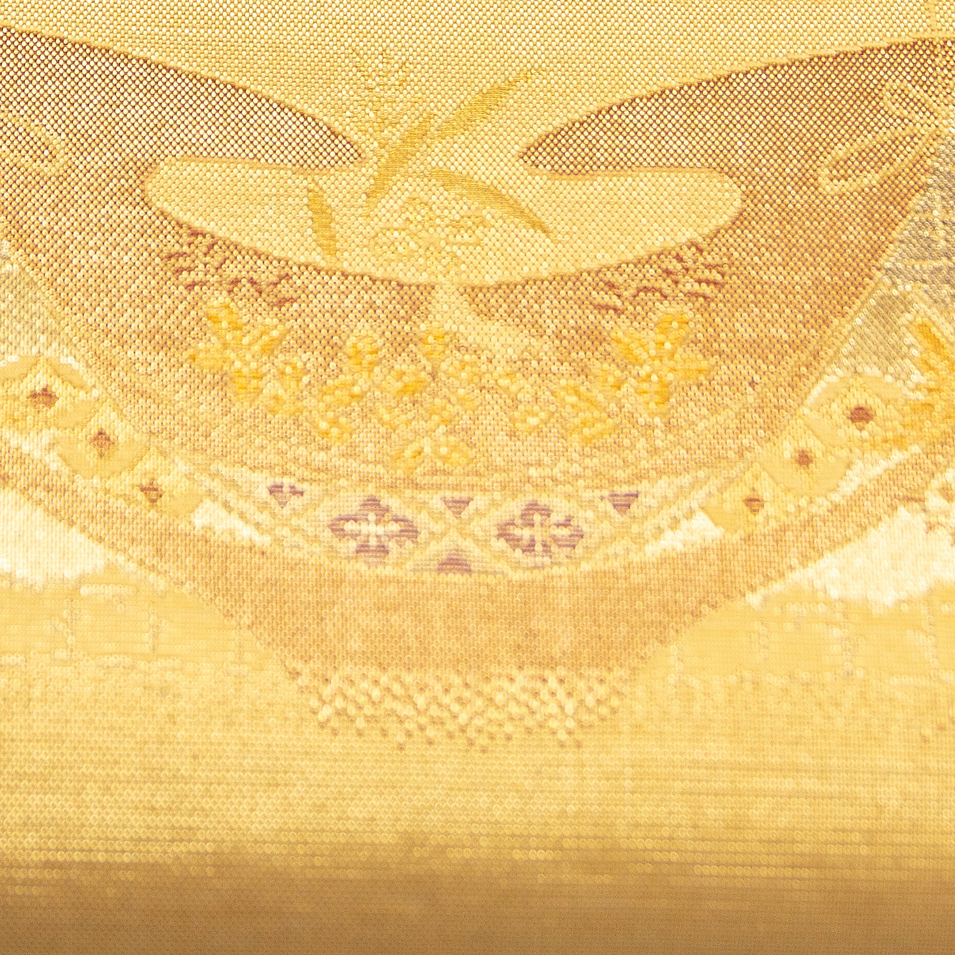 Close-up of gold fabric with intricate patterns and designs. Gold kimono silk clutch bag detail of pattern.