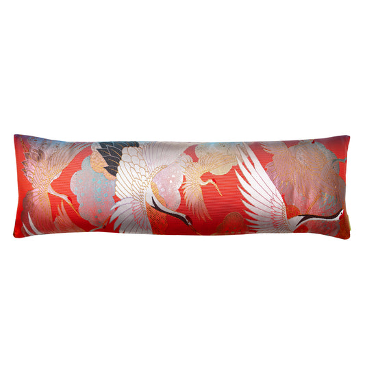 Photo of a long red pillow on a white background The pillow has flying cranes and clouds over a striped red base. Repurposed wedding kimono silk cushion.