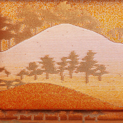 Metallic gold, bronze and orange brocade silk showing mountains and trees in a scenic landscape. Design on front of the vintage Japanese clutch bag.