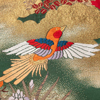 Oriental bird pillow detail over dark green silk.