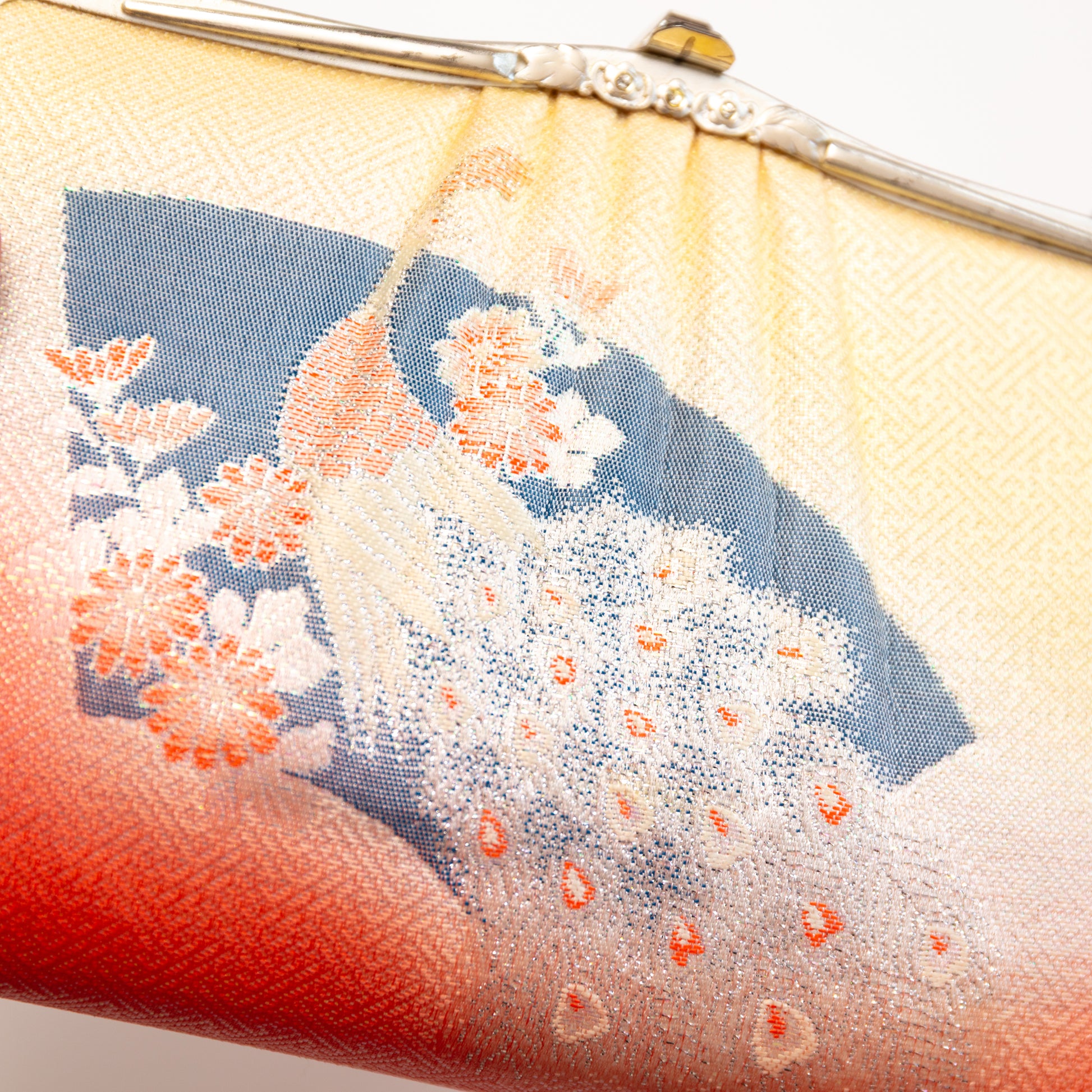 Close-up of a vintage 1950s Japanese silk handbag with peacock design and red base