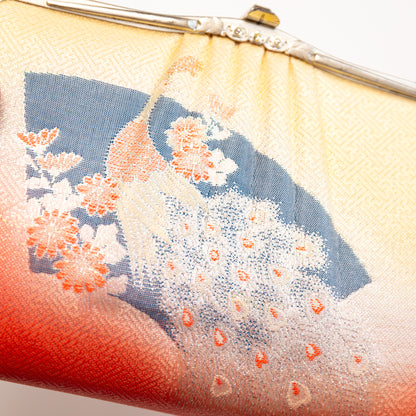 Close-up of a vintage 1950s Japanese silk handbag with peacock design and red base