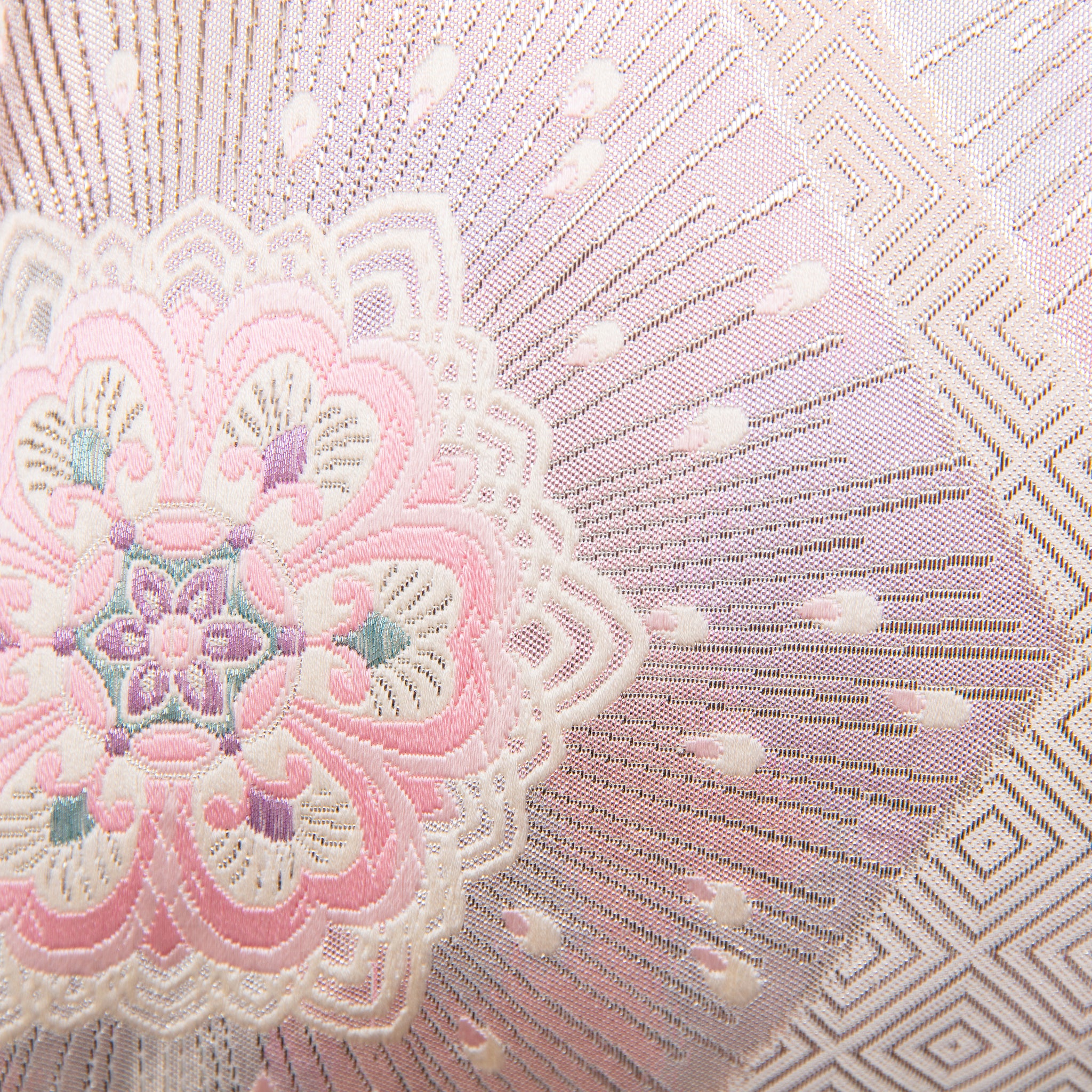 Close-up of the pink ombre silk fabric highlighting silver floral hexagon embroidery and textured diagonal stripe details