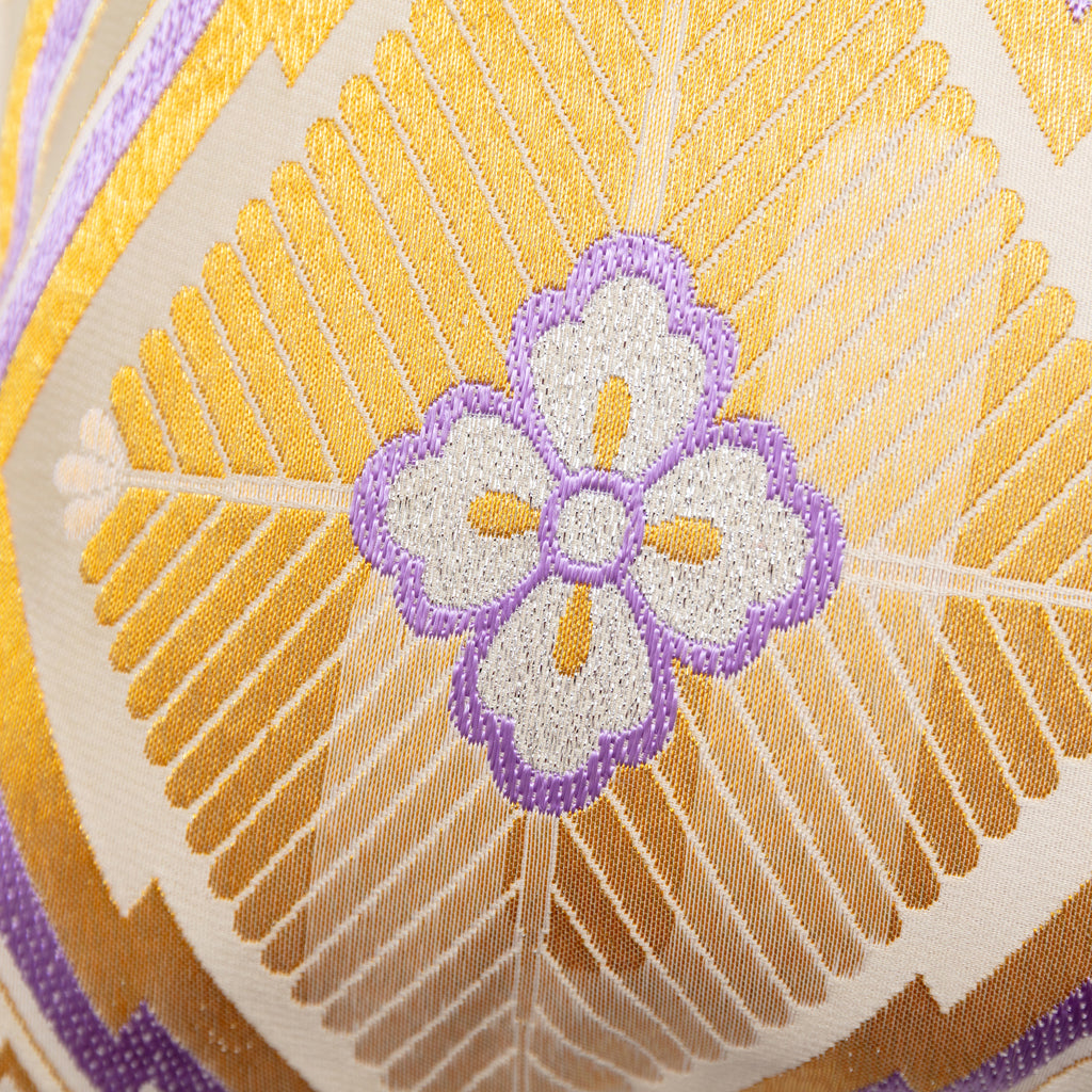 Close-up of the gold diamond embroidery detail with purple accents and intricate texture on the vintage Hanabishi obi