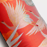 Photo showing section of pillow, red striped silk with flying gold and white cranes.