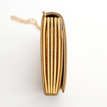 Side view of a metallic vintage Japanese gold clutch purse on a white background