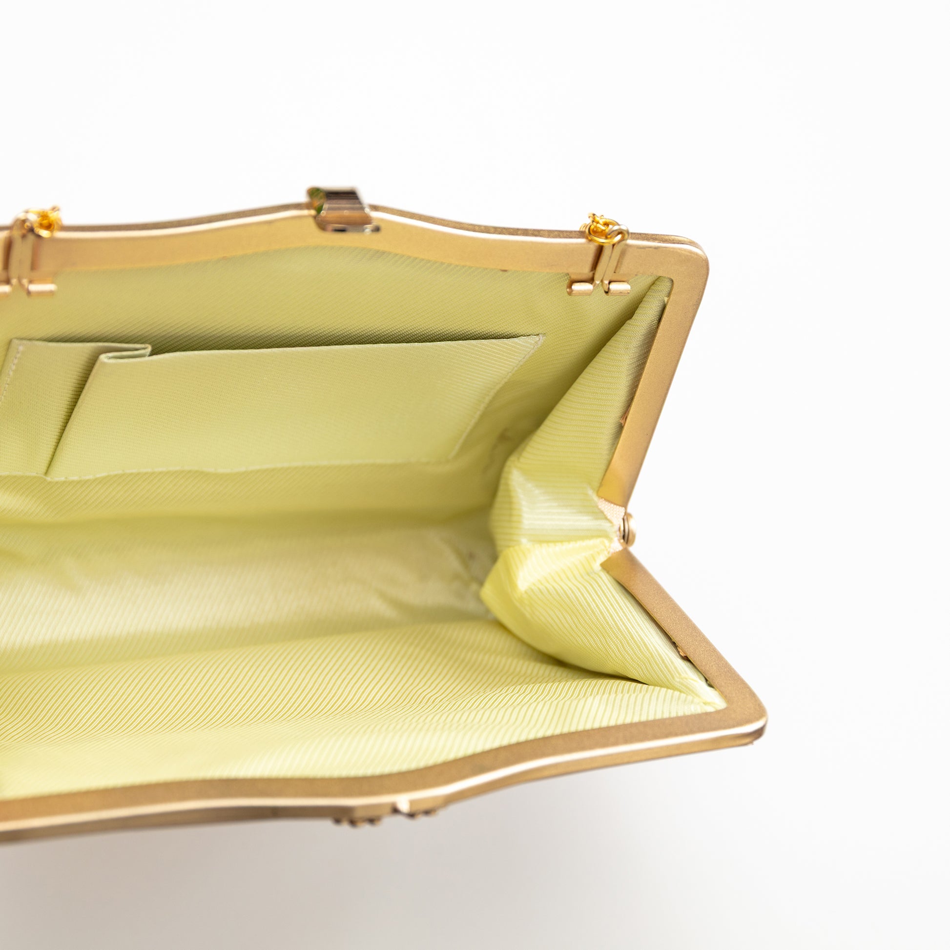 Yellow silk lined handbag with gold trim on a white background