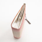 Close-up of pink silk fabric highlighting subtle ombre gradation and delicate hand-stitched embroidery details.