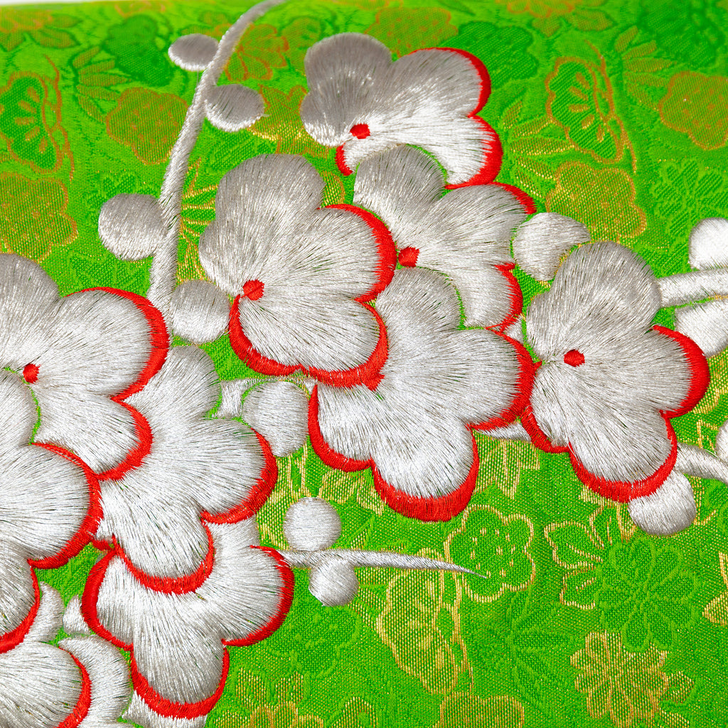 Close-up of silver blossom embroidered detail on the green silk kimono pillow fabric with snowdrift satin backing