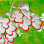 Close-up of silver blossom embroidered detail on the green silk kimono pillow fabric with snowdrift satin backing