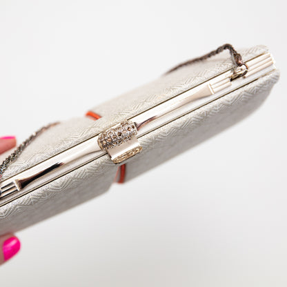 Woven silver and white vintage kimono silk  clutch bag with decorative clasp on a white background