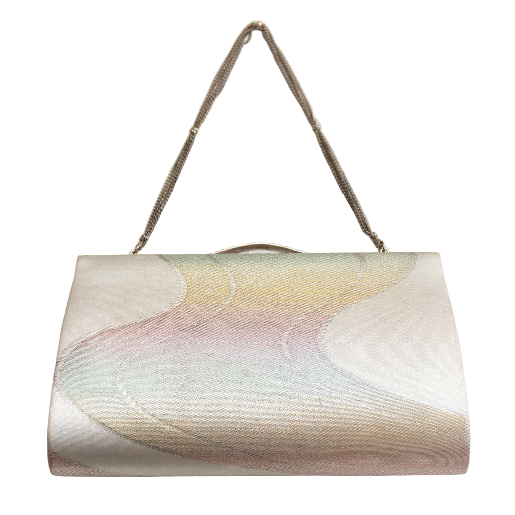Close-up of iridescent river surface pattern on vintage silver kimono clutch with subtle metallic sheen and textured