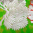 Close-up of the Green Silk Kimono Pillow's silver blossom embroidery and snowdrift satin back fabric detail from a diagonal