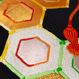 Detail of vintage obi pillow showing hexagons with coloured silk borders over a black silk ground.