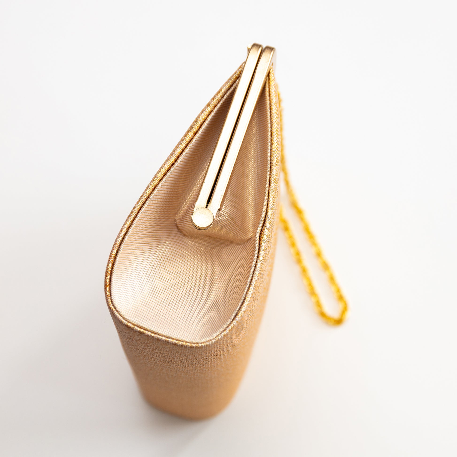 Gold clutch bag with a gold chain strap on a light gray background
