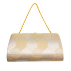 Close-up of the gold clutch’s vintage Japanese silk fabric highlighting intricate hexagon embroidery and subtle metallic