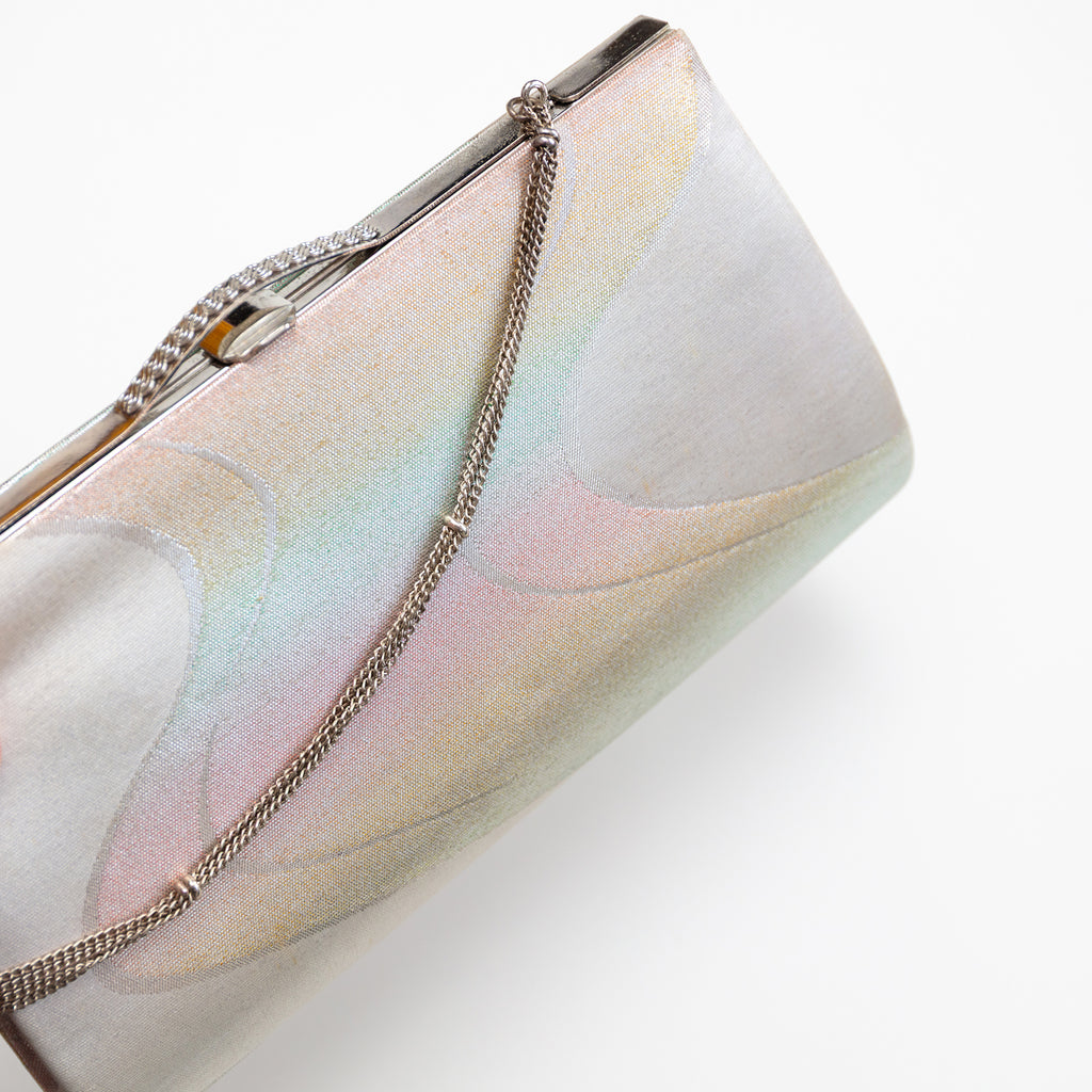 Close-up of iridescent river pattern and textured silver chain detail on vintage Japanese kimono clutch corner.