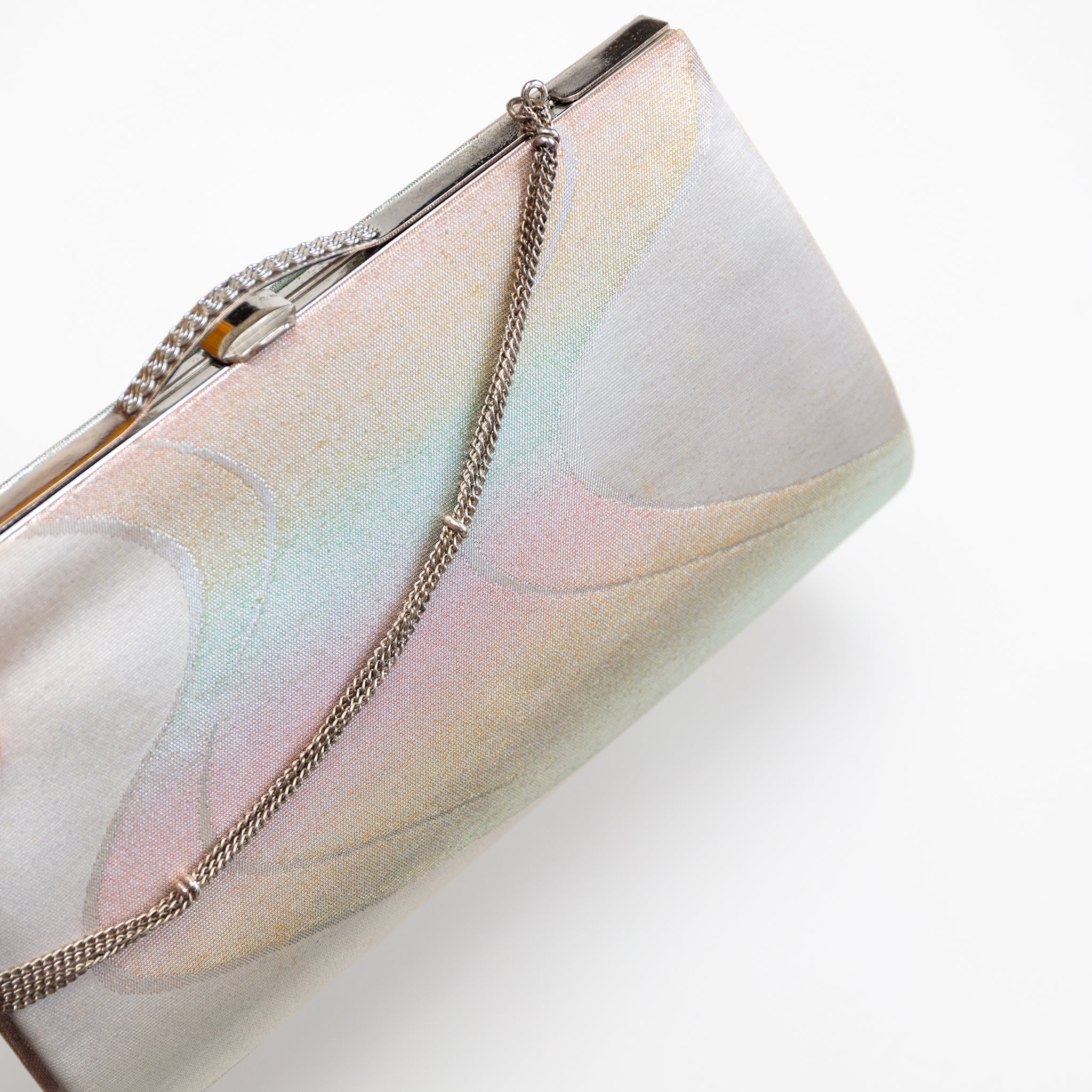 Close-up of iridescent river pattern and textured silver chain detail on vintage Japanese kimono clutch corner.