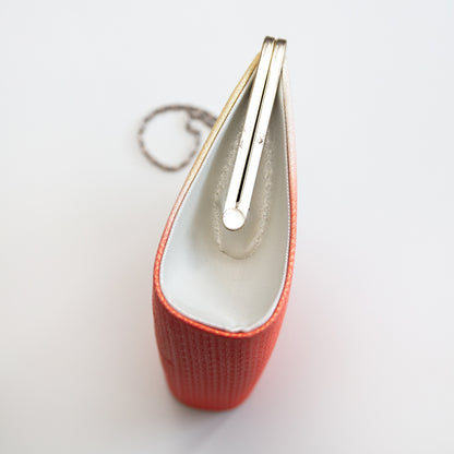 Side view of the vintage Japanese clutch bag with silver frame and chain and silver silk side panel on white background