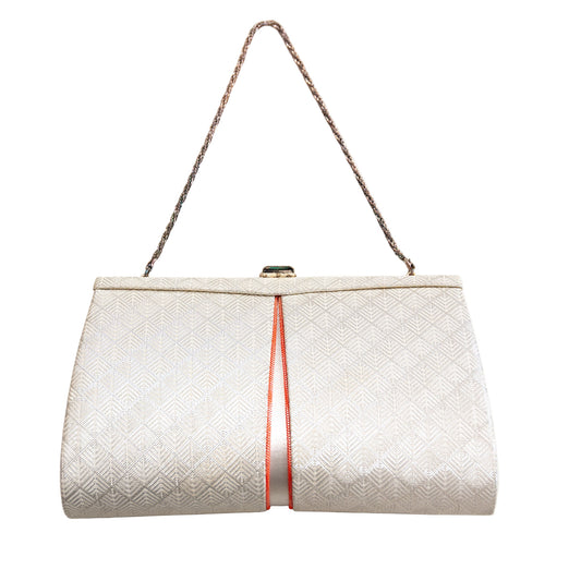 White textured handbag with a silver fancy chain strap and orange accents on a white background