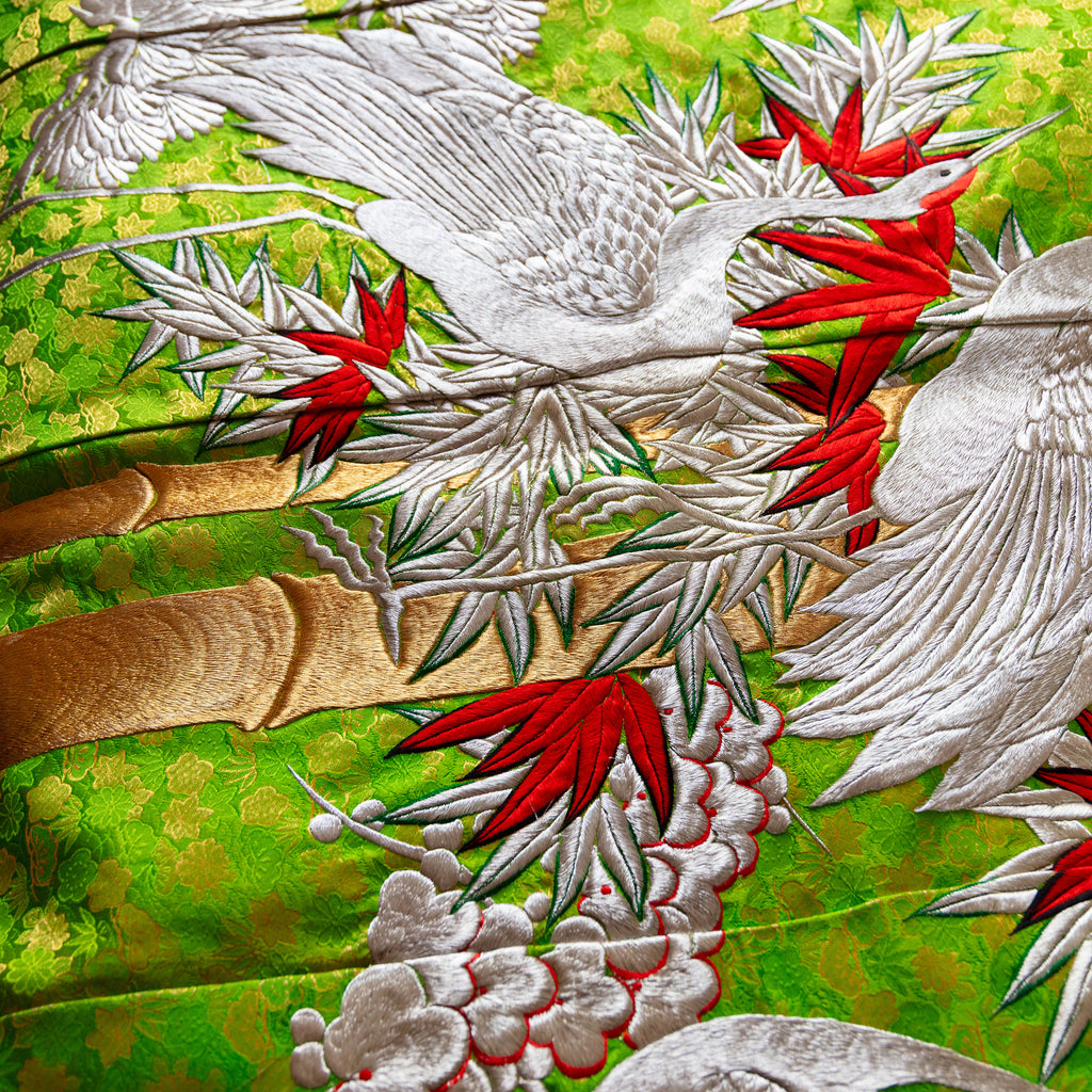 Close-up of delicate silk embroidery and intricate stitching on corner of vintage kimono blanket, highlighting craftsmanship