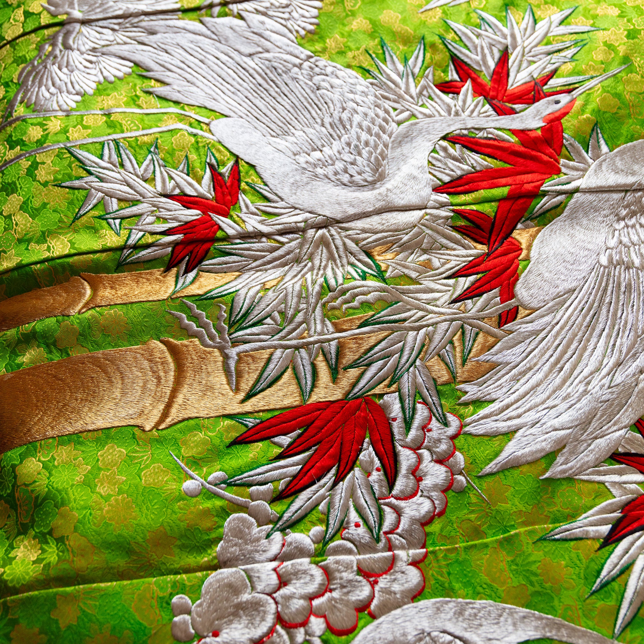 Close-up of delicate silk embroidery and intricate stitching on corner of vintage kimono blanket, highlighting craftsmanship