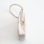 Close-up of pink and white beadwork pattern highlighting intricate embroidery and shimmering texture along the bag's upper