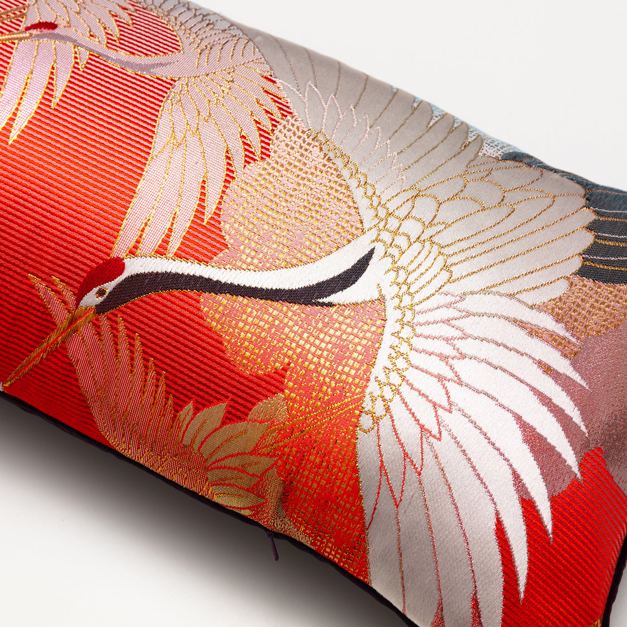 Close-up of embroidered flying cranes and intricate velvet texture highlighting vintage Uchikake details on the bolster
