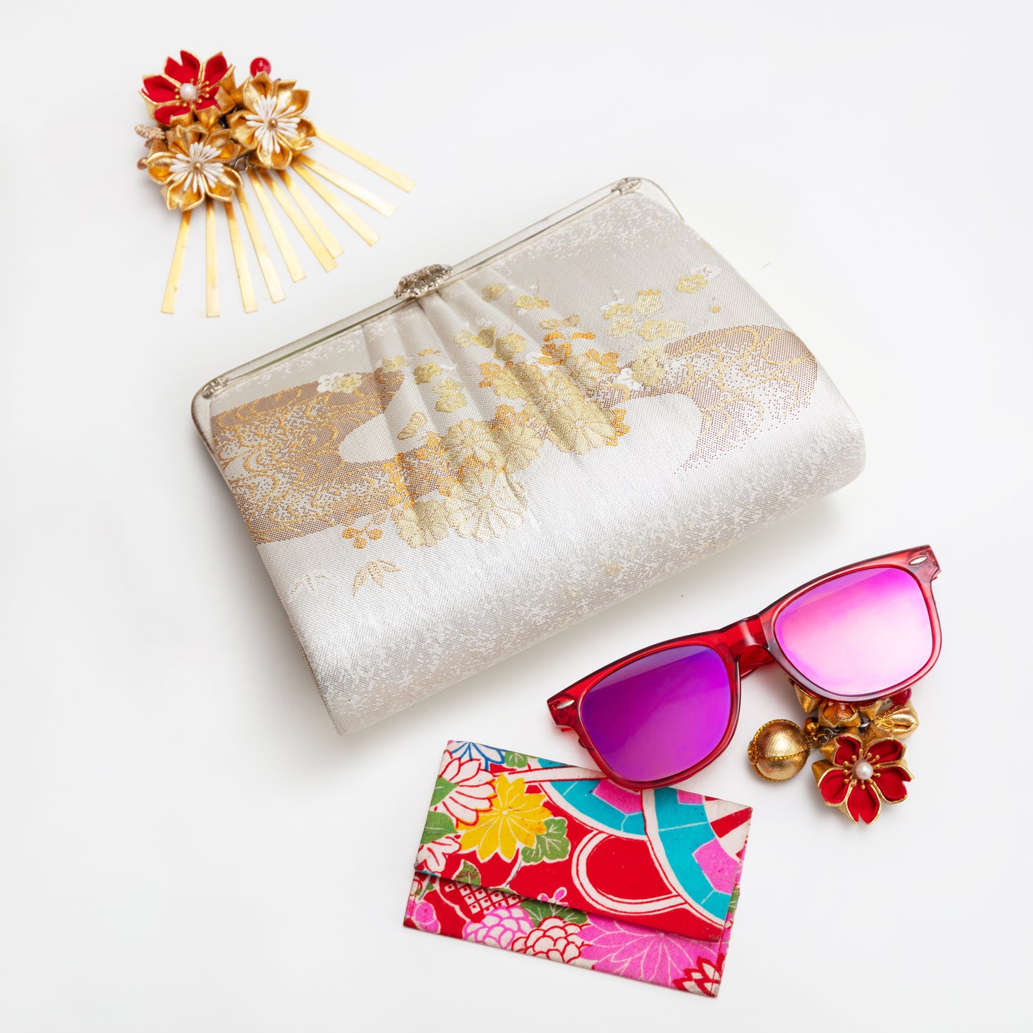 Vintage Japanese clutch, sunglasses, and hair accessories on a white background