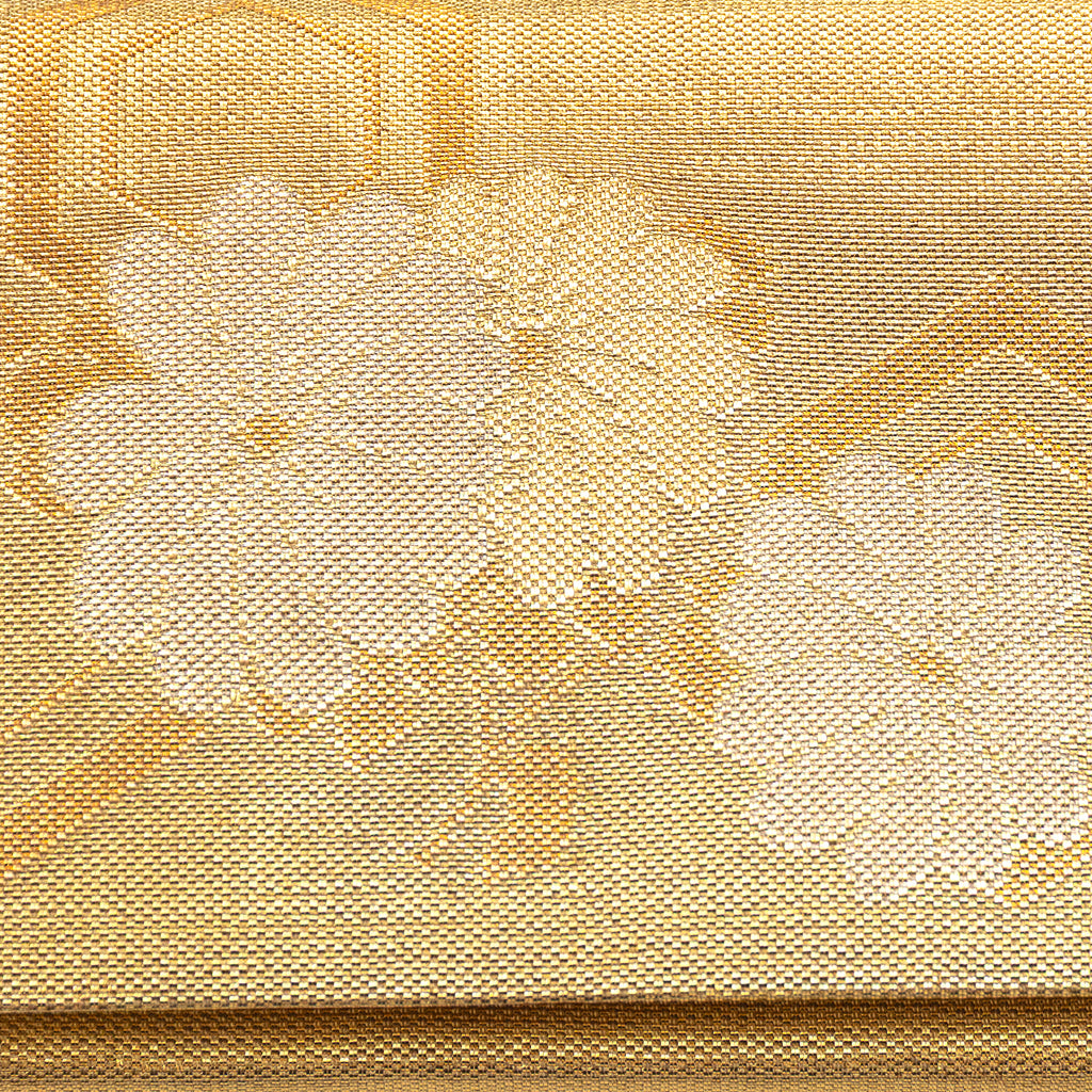 Close-up of gold metallic fabric and intricate floral embroidery on the foldover clutch’s front, highlighting vintage