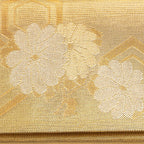Close-up of gold metallic fabric and intricate floral embroidery on the foldover clutch’s front, highlighting vintage