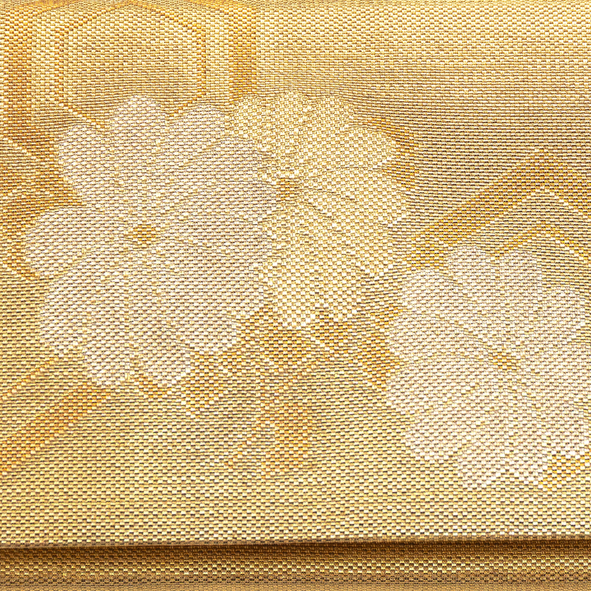 Close-up of gold metallic fabric and intricate floral embroidery on the foldover clutch’s front, highlighting vintage