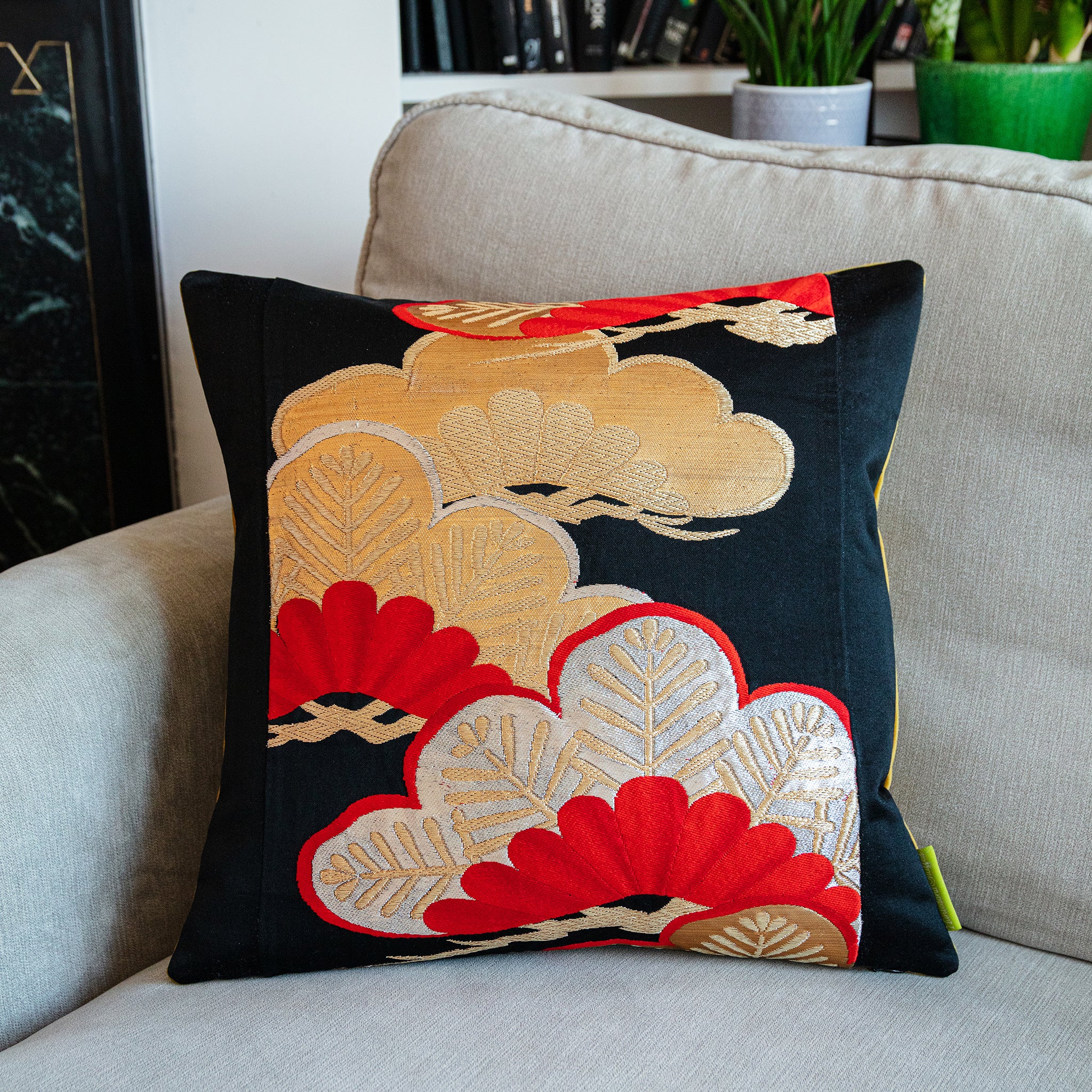 Close-up of gold velvet pinstripes and pine motif embroidery on the 16-inch black silk obi cushion fabric detail