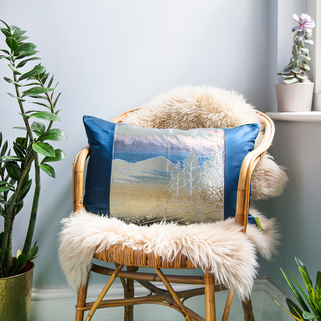 Close-up of the textured blue velvet fabric showcasing subtle silk sheen and soft folds on the cushion surface.